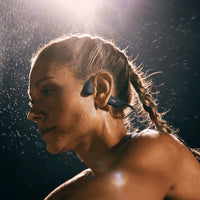 Woman exercising and sweating using Shokz OpenRun Pro running headphones in black