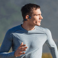Man running with Shokz OpenRun Mini running headphones in blue and black