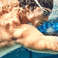 Man swimming with Shokz OpenSwim sports & swimming headphones in black