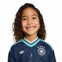 Child modelling the Germany '26 Away Football Mini Kit up close