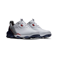 A pair of FootJoy tour alpha golf shoes in white, navy and grey.