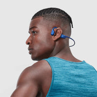 Man exercising with Shokz OpenRun Mini running headphones in blue and black